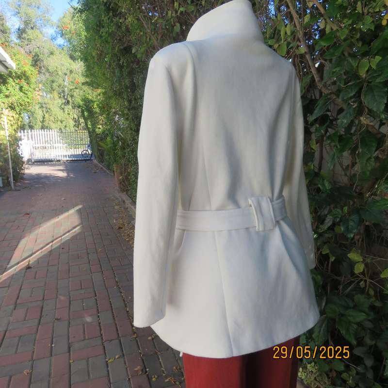 Light cream warm 100% polyester fully lined double breast jacket with belt. Size 44-46