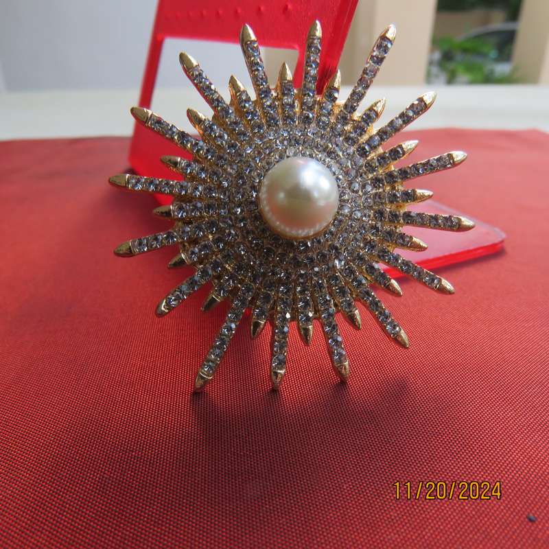 Unique shiny delicate brooch with lots of simulated diamonds on gold. Faux pearl in center.New item