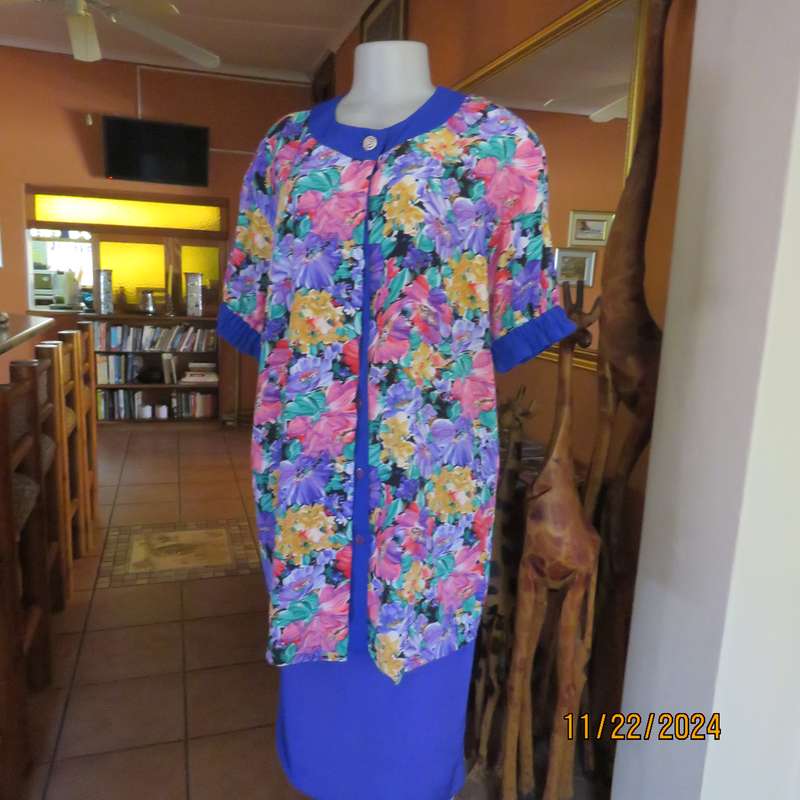Stunning long floral-royal blue button down short sleeve top in silky polyester.Size 40-42. As new