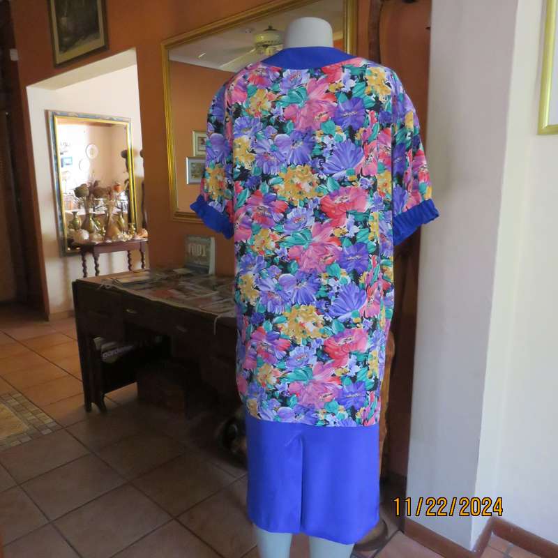 Stunning long floral-royal blue button down short sleeve top in silky polyester.Size 40-42. As new
