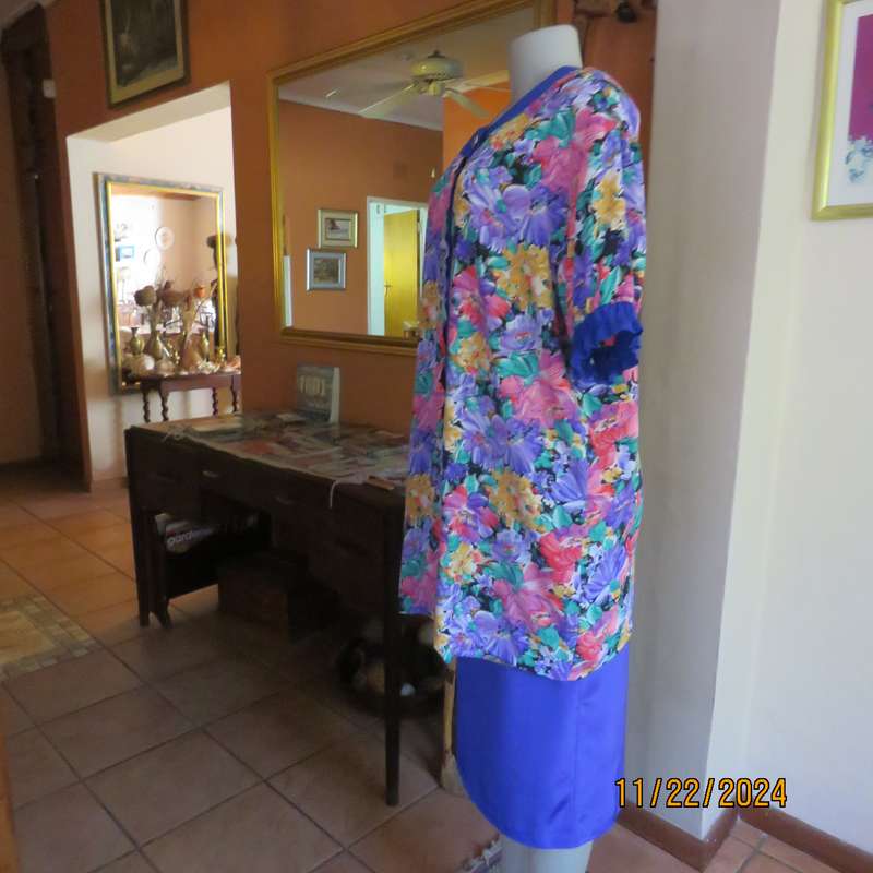 Stunning long floral-royal blue button down short sleeve top in silky polyester.Size 40-42. As new
