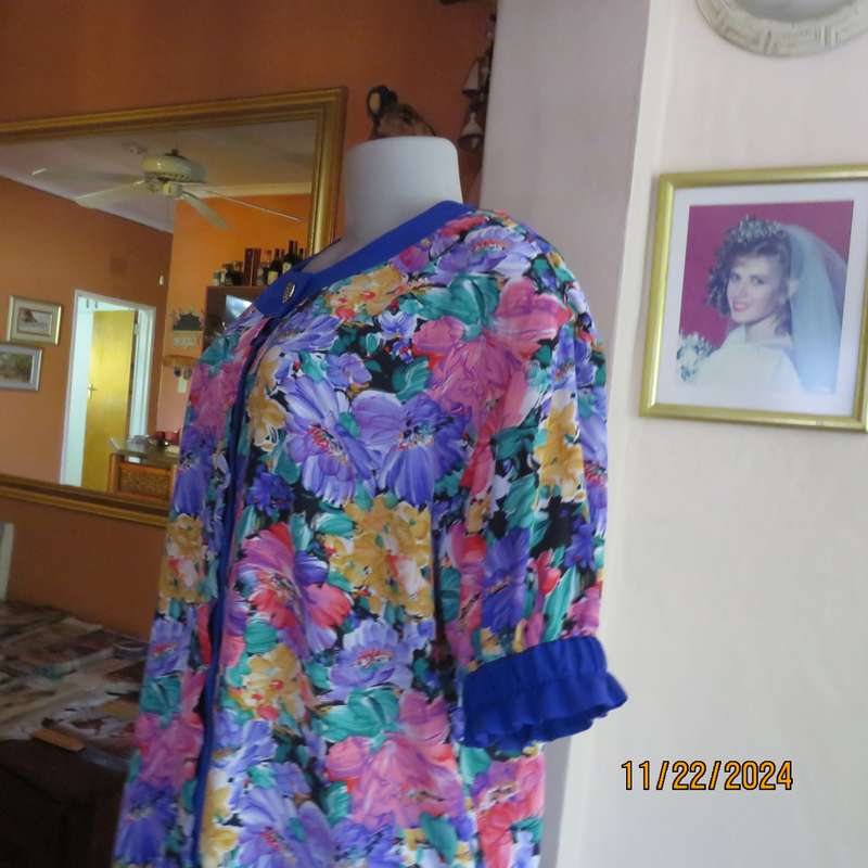 Stunning long floral-royal blue button down short sleeve top in silky polyester.Size 40-42. As new