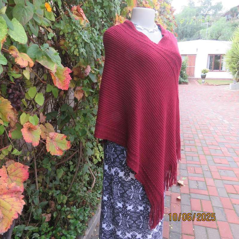 Maroon acrylic knit poncho partly fringed to fit size 32 to 36.