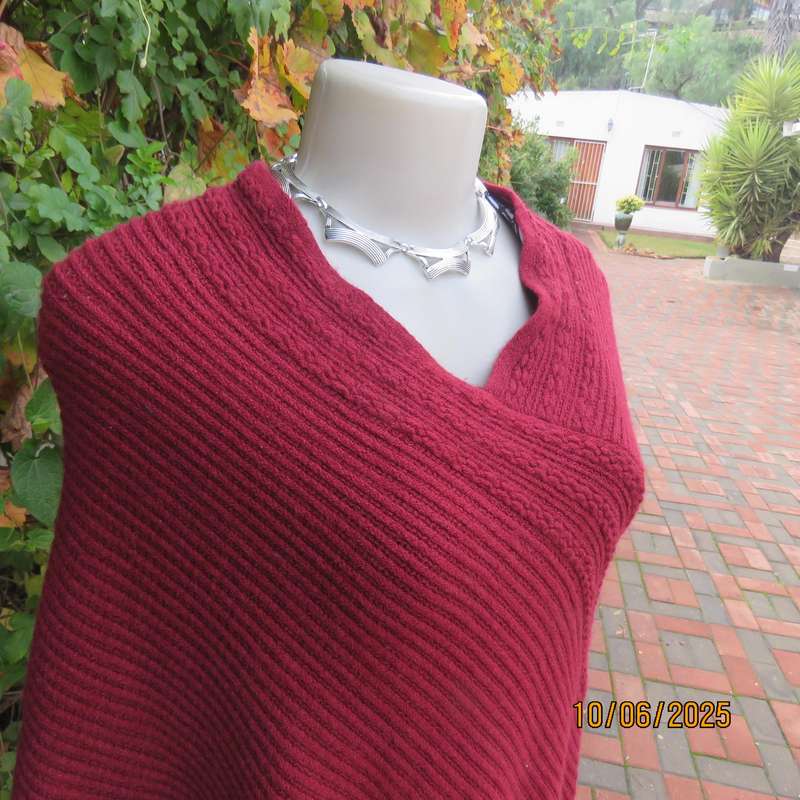 Maroon acrylic knit poncho partly fringed to fit size 32 to 36.