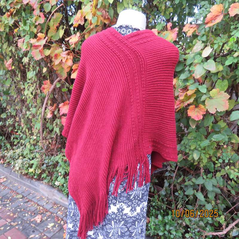 Maroon acrylic knit poncho partly fringed to fit size 32 to 36.