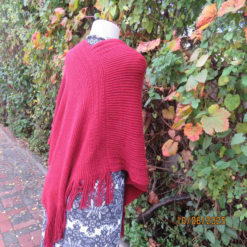 Maroon acrylic knit poncho partly fringed to fit size 32 to 36.