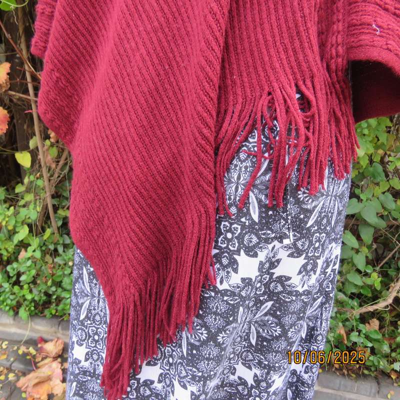 Maroon acrylic knit poncho partly fringed to fit size 32 to 36.