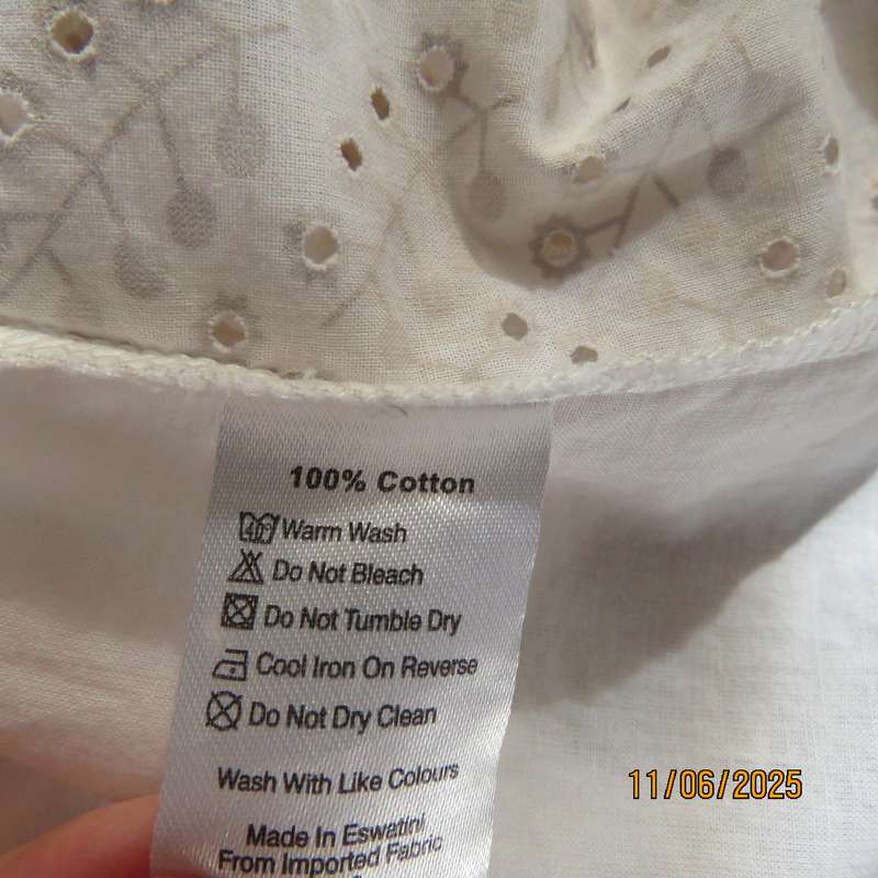 White cotton slip over top. Front and sleeves with eyelet embroidery. Size 36