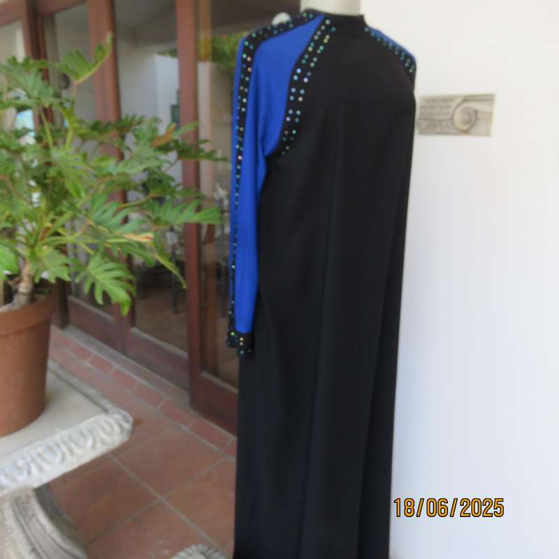 Black long sleeve polyester-rayon floor length dress. Blue inlays. Size 40