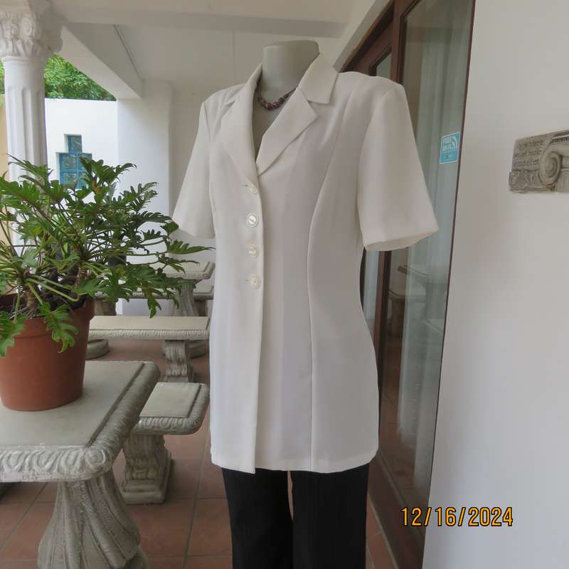 Elegant light cream tailored jacket closing with 4 front buttons. Collar and short sleeves.Size 34