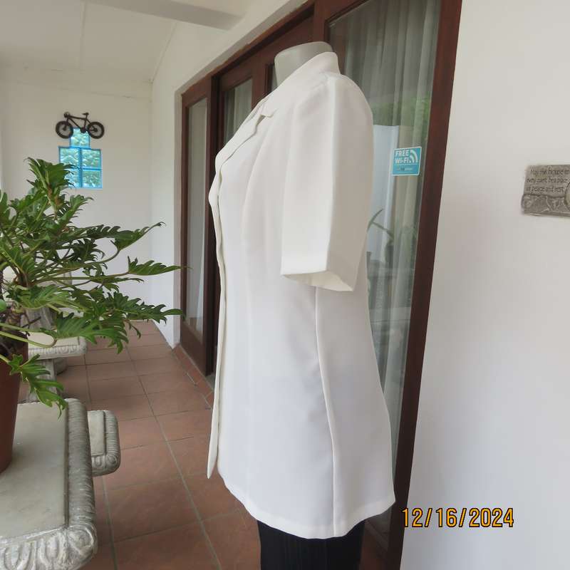 Elegant light cream tailored jacket closing with 4 front buttons. Collar and short sleeves.Size 34