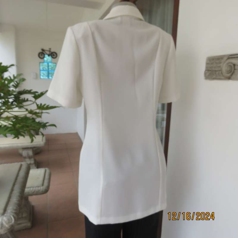 Elegant light cream tailored jacket closing with 4 front buttons. Collar and short sleeves.Size 34