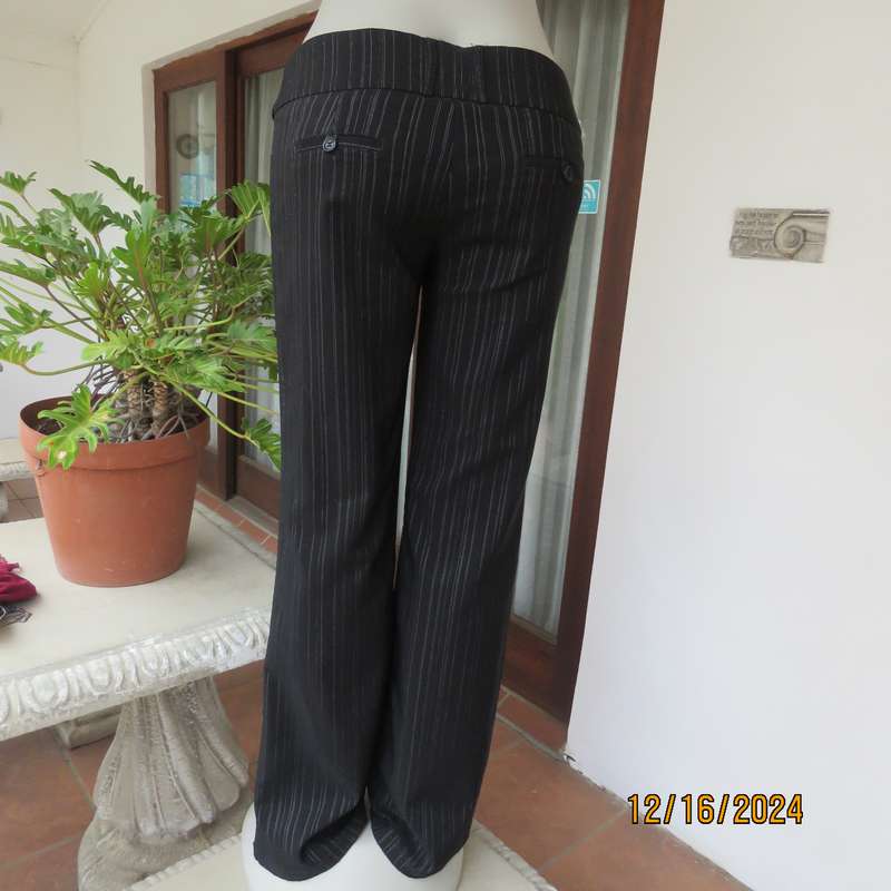 Black pinstripe bootlegged polyester-rayon stretch pants size 34. Dummy pockets at back. As new con.