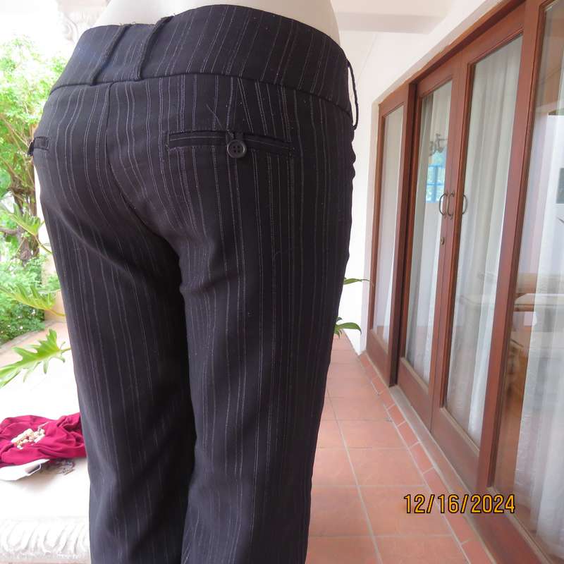 Black pinstripe bootlegged polyester-rayon stretch pants size 34. Dummy pockets at back. As new con.