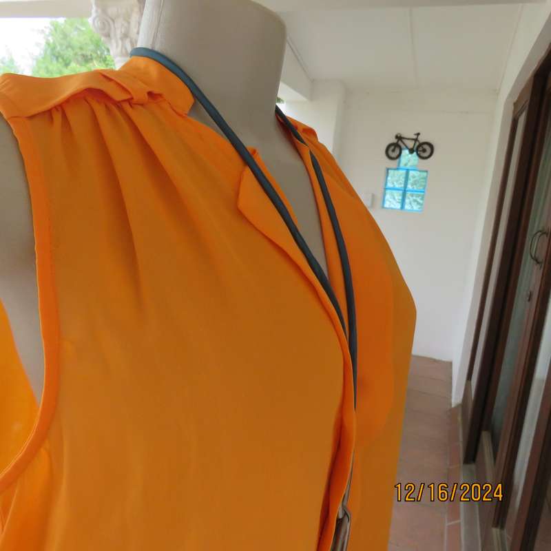 Tangerine cool slip over polyester V front top. Gathered front shoulders. Longer back.Slits.Size 36.