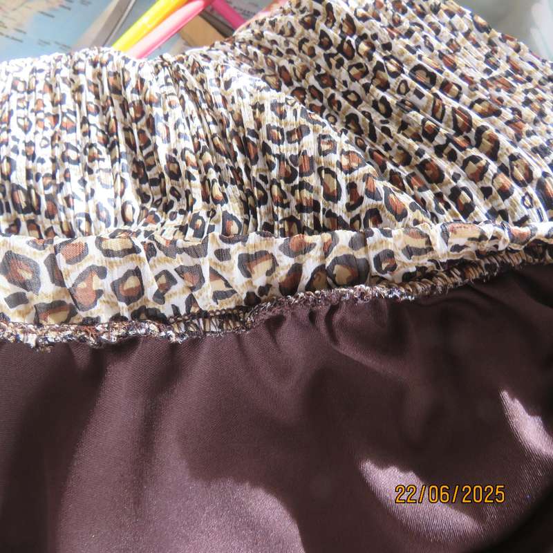 Animal print permanent pleated skirt with brown stretch polyester inner layer. Size 46