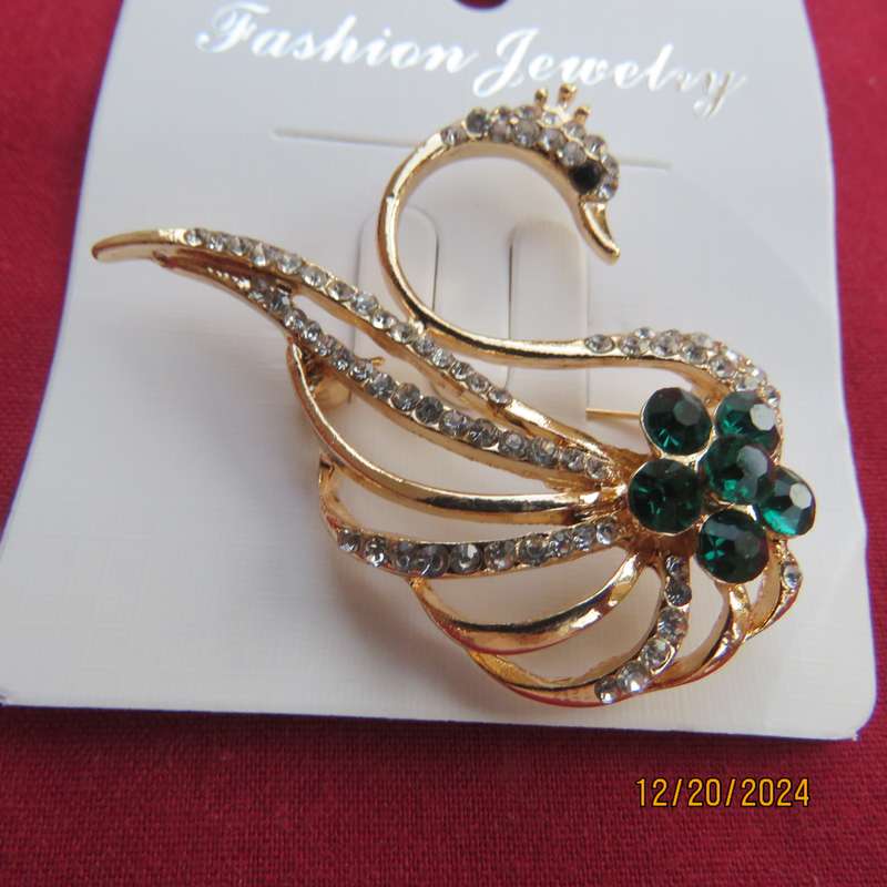 Fashion golden swan brooch with faux diamonds and green Rhinestones. 4.5cm x 3.5cm.New item.