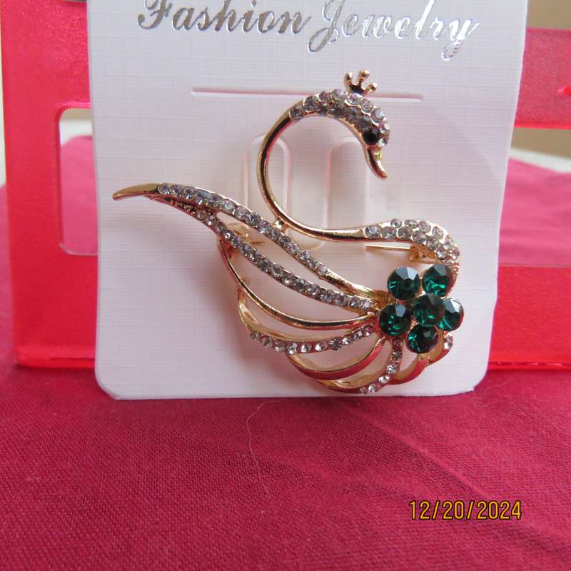 Fashion golden swan brooch with faux diamonds and green Rhinestones. 4.5cm x 3.5cm.New item.