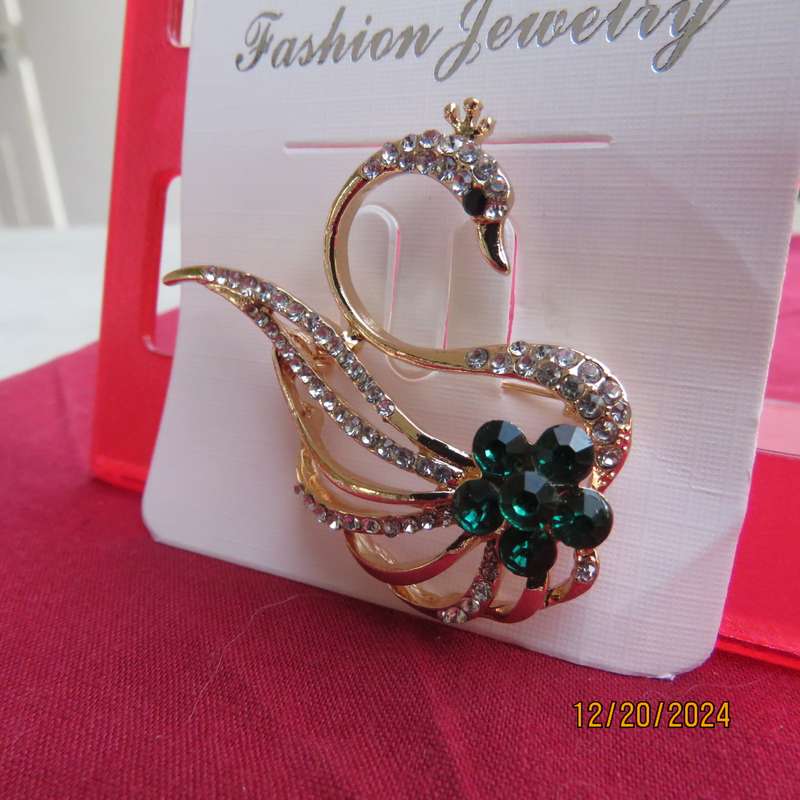Fashion golden swan brooch with faux diamonds and green Rhinestones. 4.5cm x 3.5cm.New item.