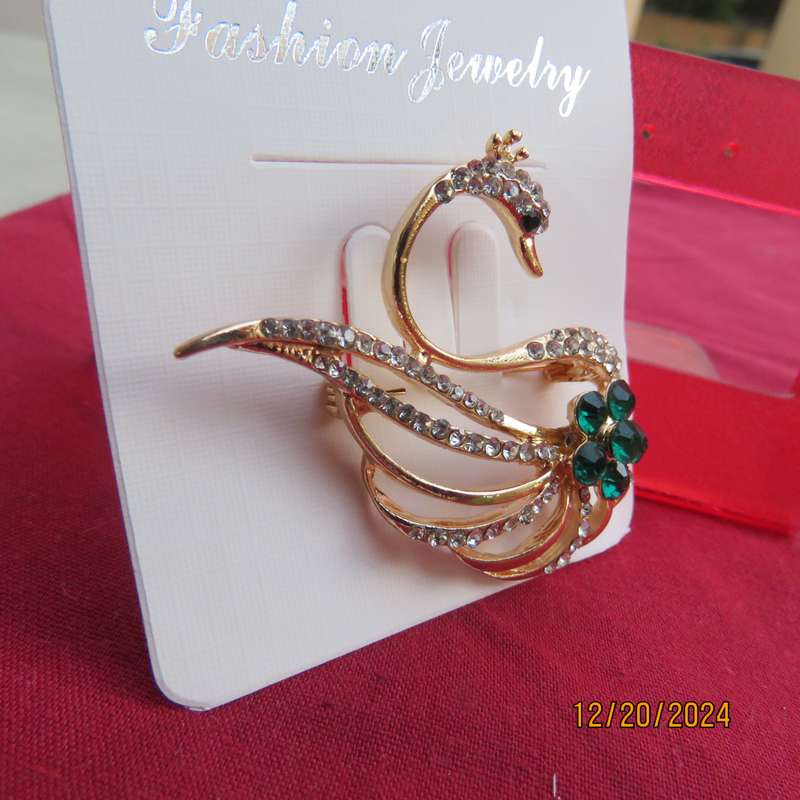 Fashion golden swan brooch with faux diamonds and green Rhinestones. 4.5cm x 3.5cm.New item.
