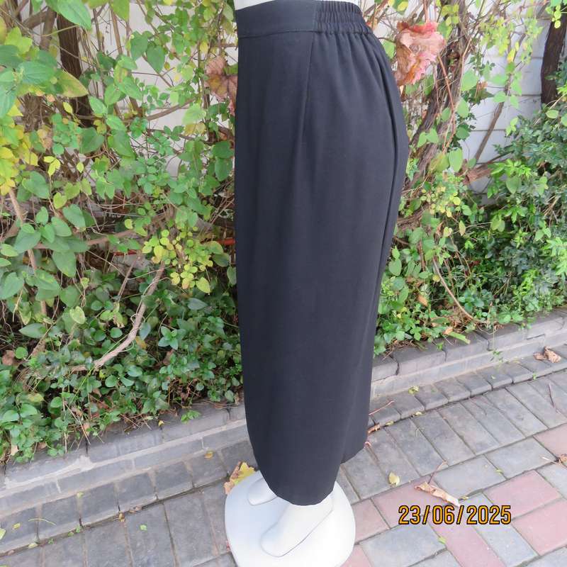 Very black lined ankle length polyester pencil skirt. Size 44 loose fit. Elasticated sides.