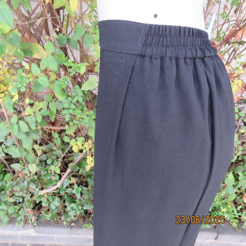 Very black lined ankle length polyester pencil skirt. Size 44 loose fit. Elasticated sides.
