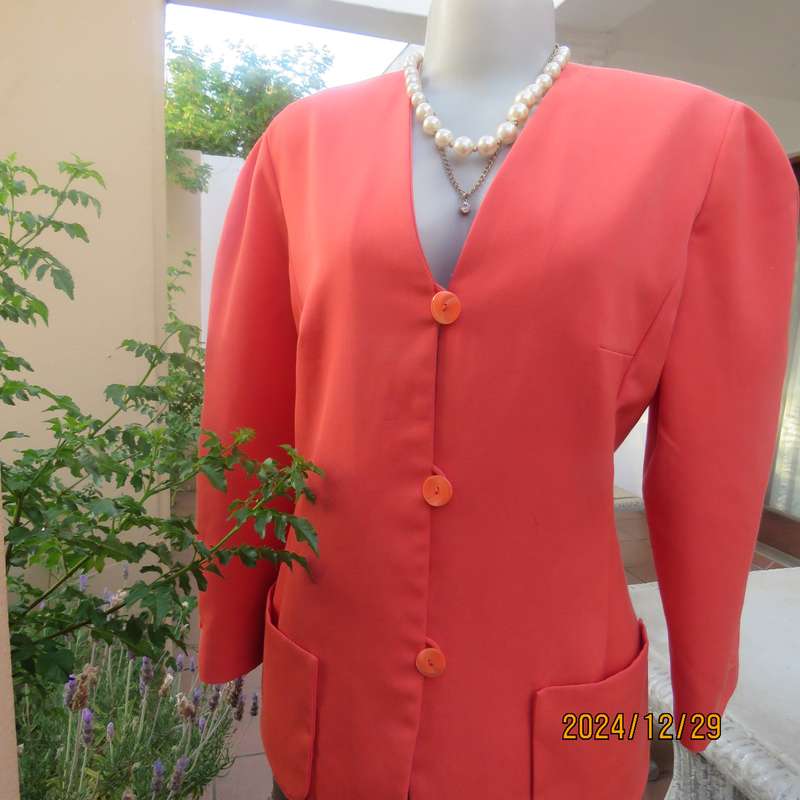 Stunning boutique made papaya colour long sleeve lined collarless jacket.Size 38.Poly-viscose blend.