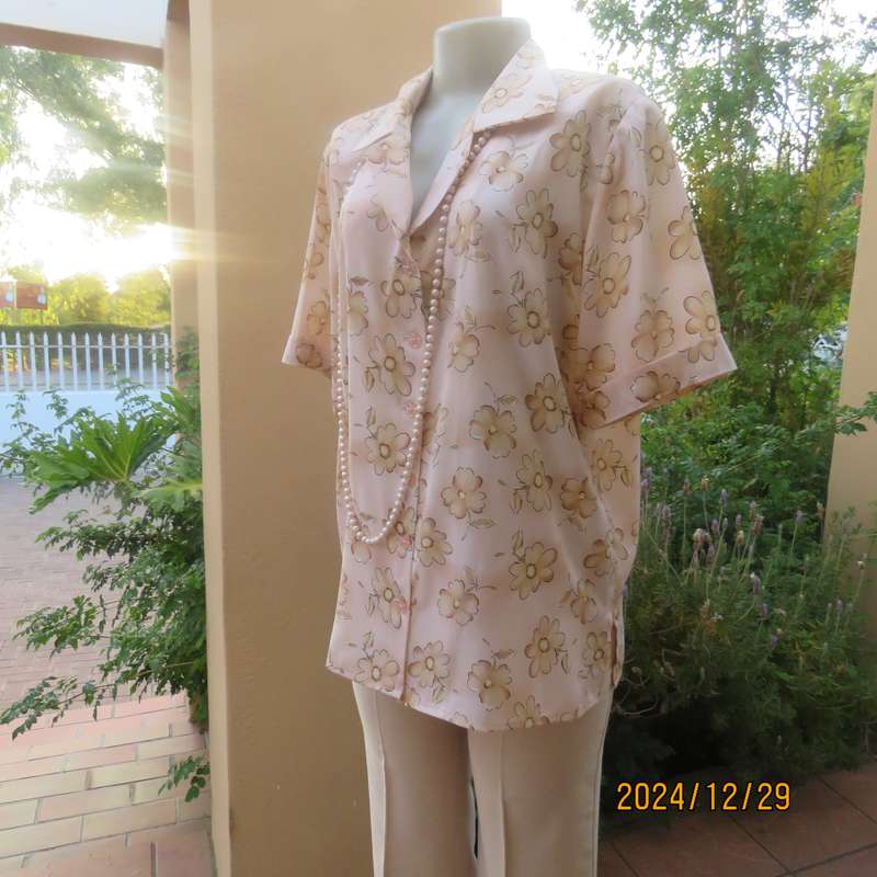 Tastefully printed flowers on pale peach background silky polyester short sleeve top.Size 40. As new