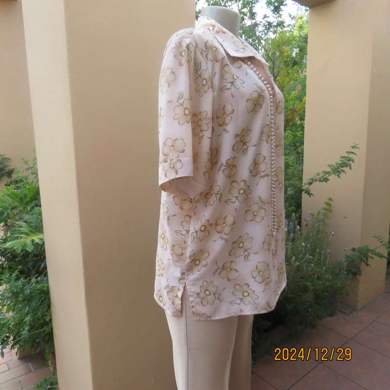 Tastefully printed flowers on pale peach background silky polyester short sleeve top.Size 40. As new