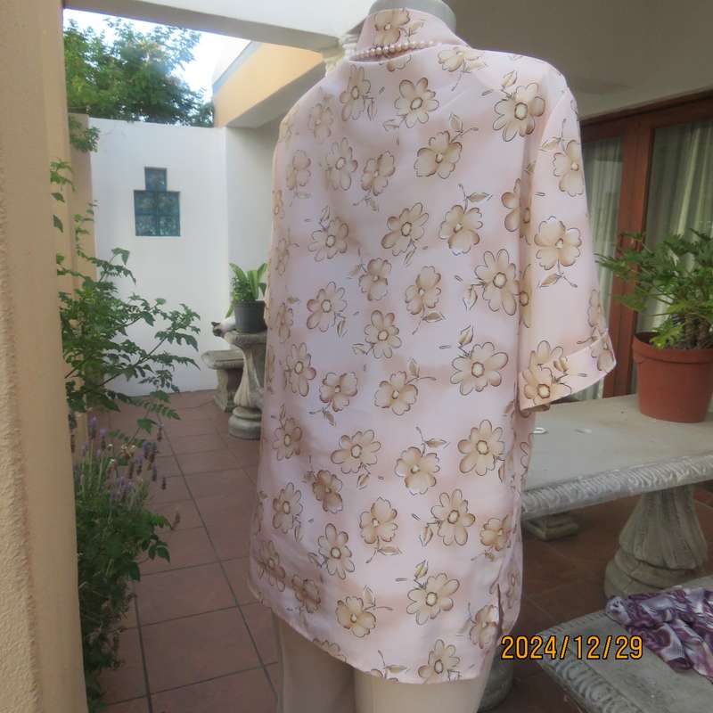 Tastefully printed flowers on pale peach background silky polyester short sleeve top.Size 40. As new