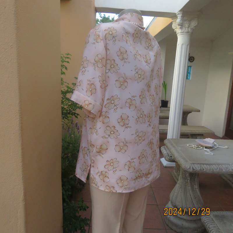Tastefully printed flowers on pale peach background silky polyester short sleeve top.Size 40. As new