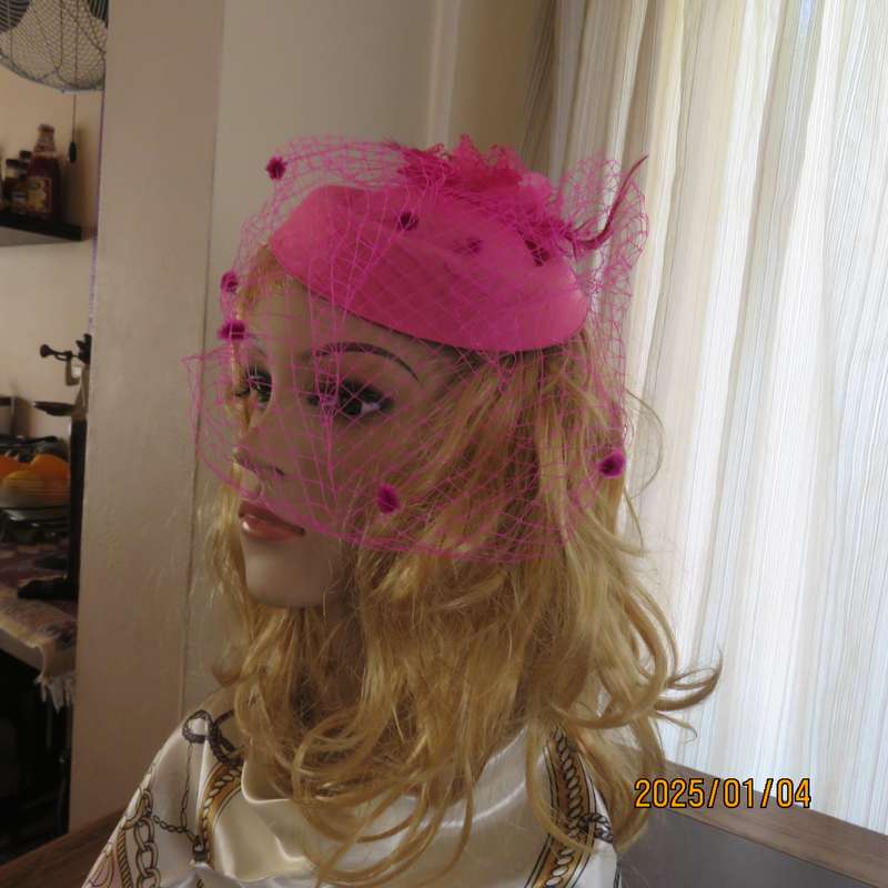 Magenta pink pillbox style fascinator.Netting on front.Flower and feathers. Thin satin alice band.
