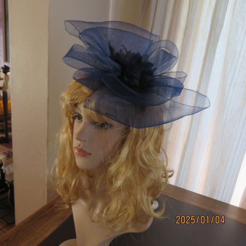 Make a statement wearing this navy double bow mesh fascinator with flower and feathers. New item