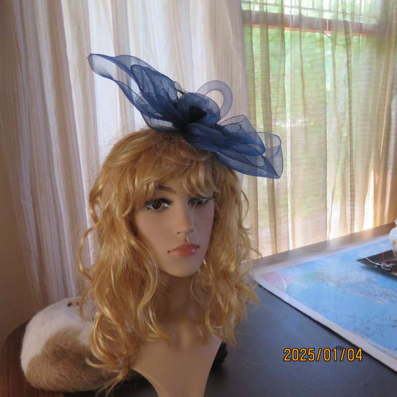 Make a statement wearing this navy double bow mesh fascinator with flower and feathers. New item