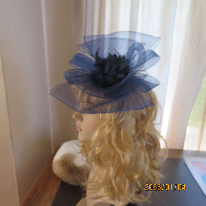 Make a statement wearing this navy double bow mesh fascinator with flower and feathers. New item