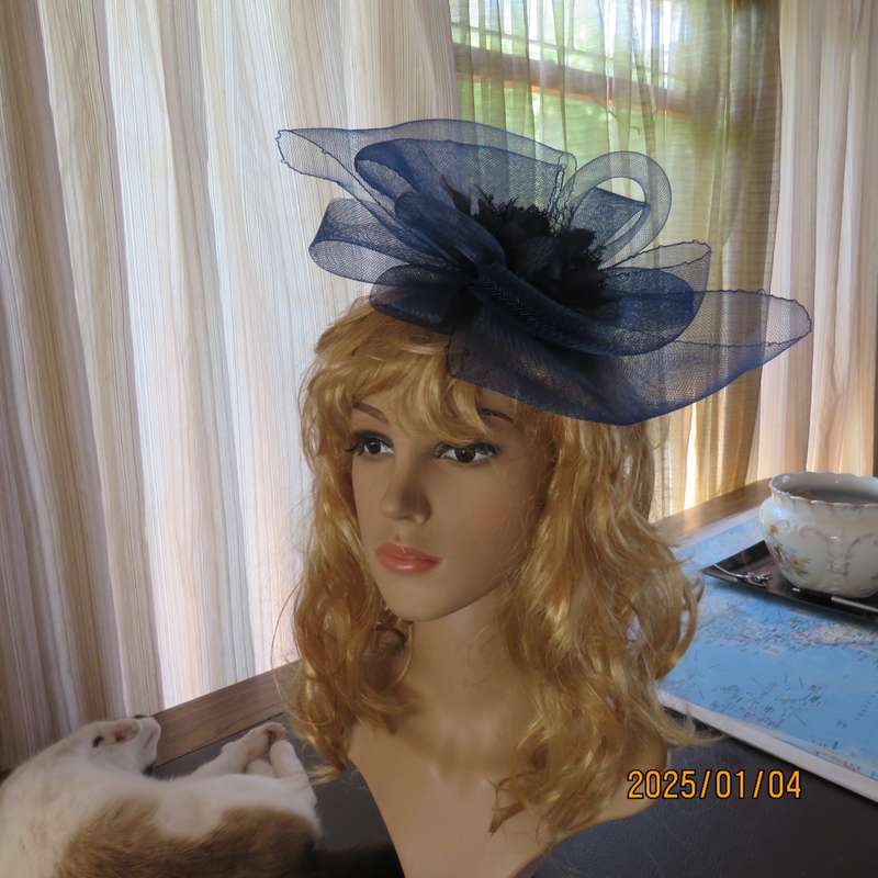 Make a statement wearing this navy double bow mesh fascinator with flower and feathers. New item