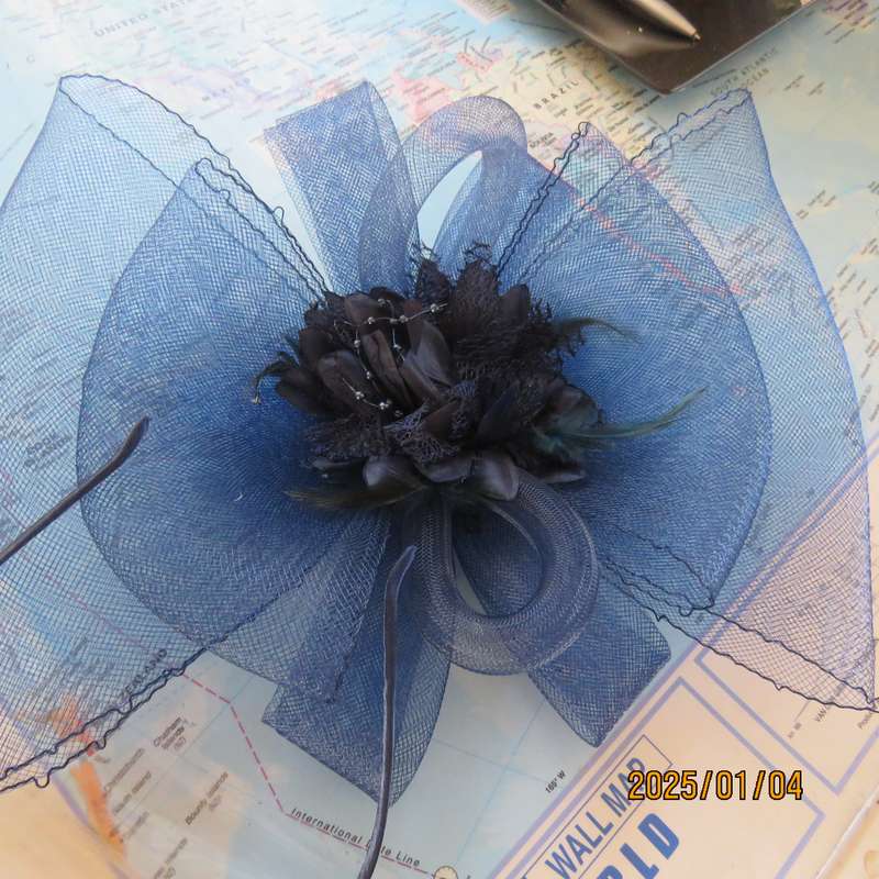 Make a statement wearing this navy double bow mesh fascinator with flower and feathers. New item