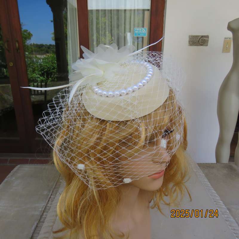 Fabulous little rich cream pillbox style fascinator with veil-pearl decoration and flower-feathers.