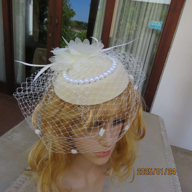 Fabulous little rich cream pillbox style fascinator with veil-pearl decoration and flower-feathers.