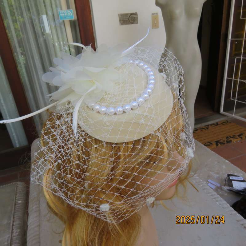 Fabulous little rich cream pillbox style fascinator with veil-pearl decoration and flower-feathers.
