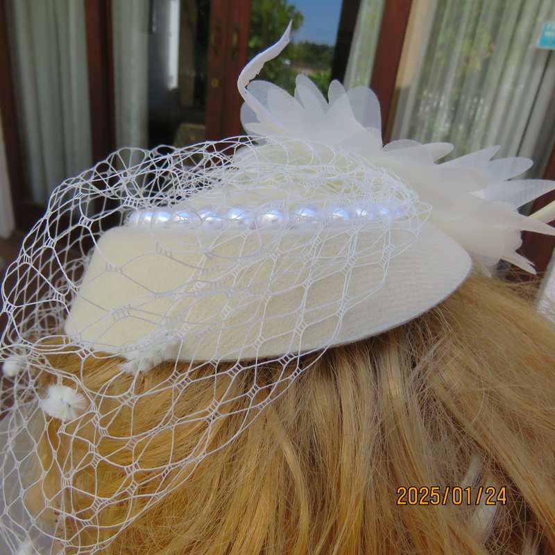 Fabulous little rich cream pillbox style fascinator with veil-pearl decoration and flower-feathers.