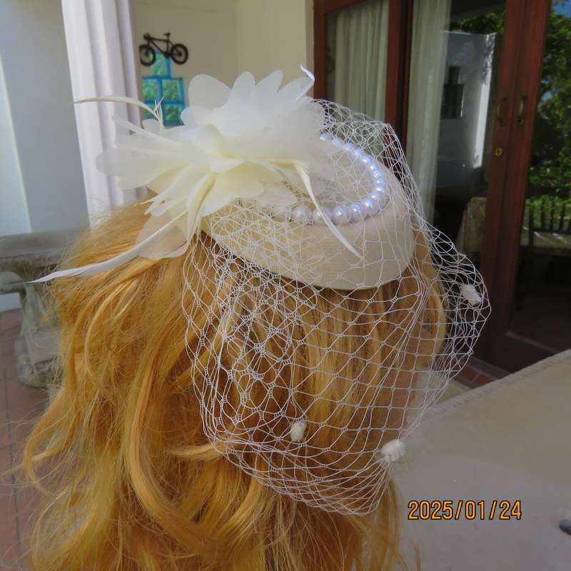 Fabulous little rich cream pillbox style fascinator with veil-pearl decoration and flower-feathers.
