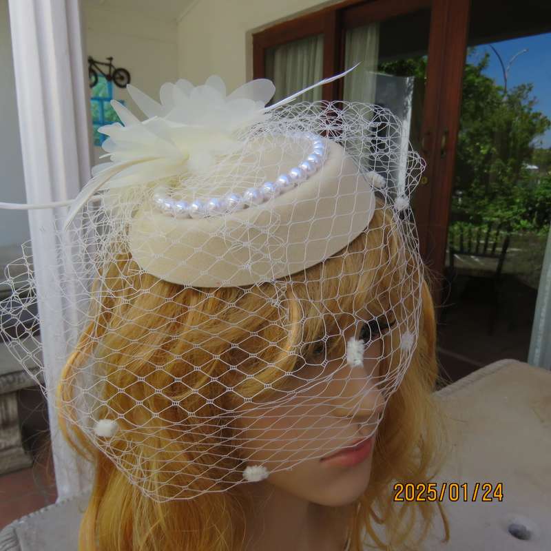 Fabulous little rich cream pillbox style fascinator with veil-pearl decoration and flower-feathers.