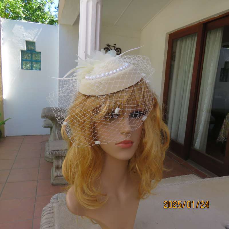 Fabulous little rich cream pillbox style fascinator with veil-pearl decoration and flower-feathers.