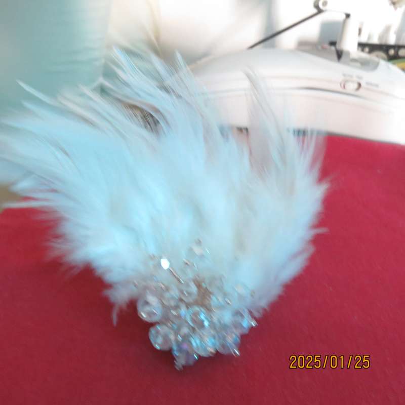 Chic romantic white feather brooch. Faux crystal flower center. Suitable for smart event. New item.