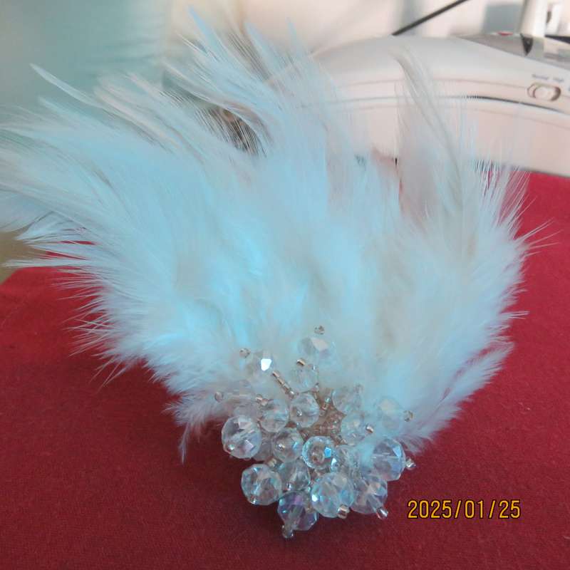 Chic romantic white feather brooch. Faux crystal flower center. Suitable for smart event. New item.