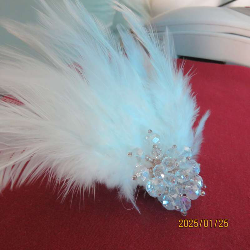 Chic romantic white feather brooch. Faux crystal flower center. Suitable for smart event. New item.