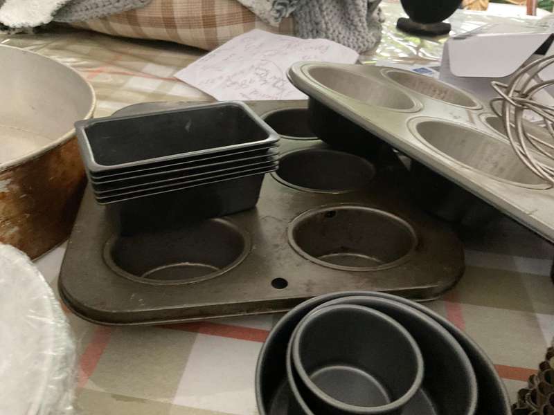 A selection of muffin baking trays, tart tins ,small cake tins and a large whisk.