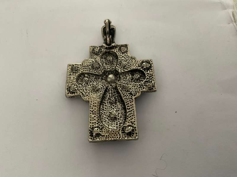 A silver metal cross with white rhinestones