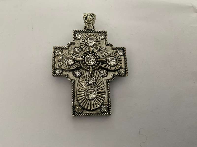 A silver metal cross with white rhinestones